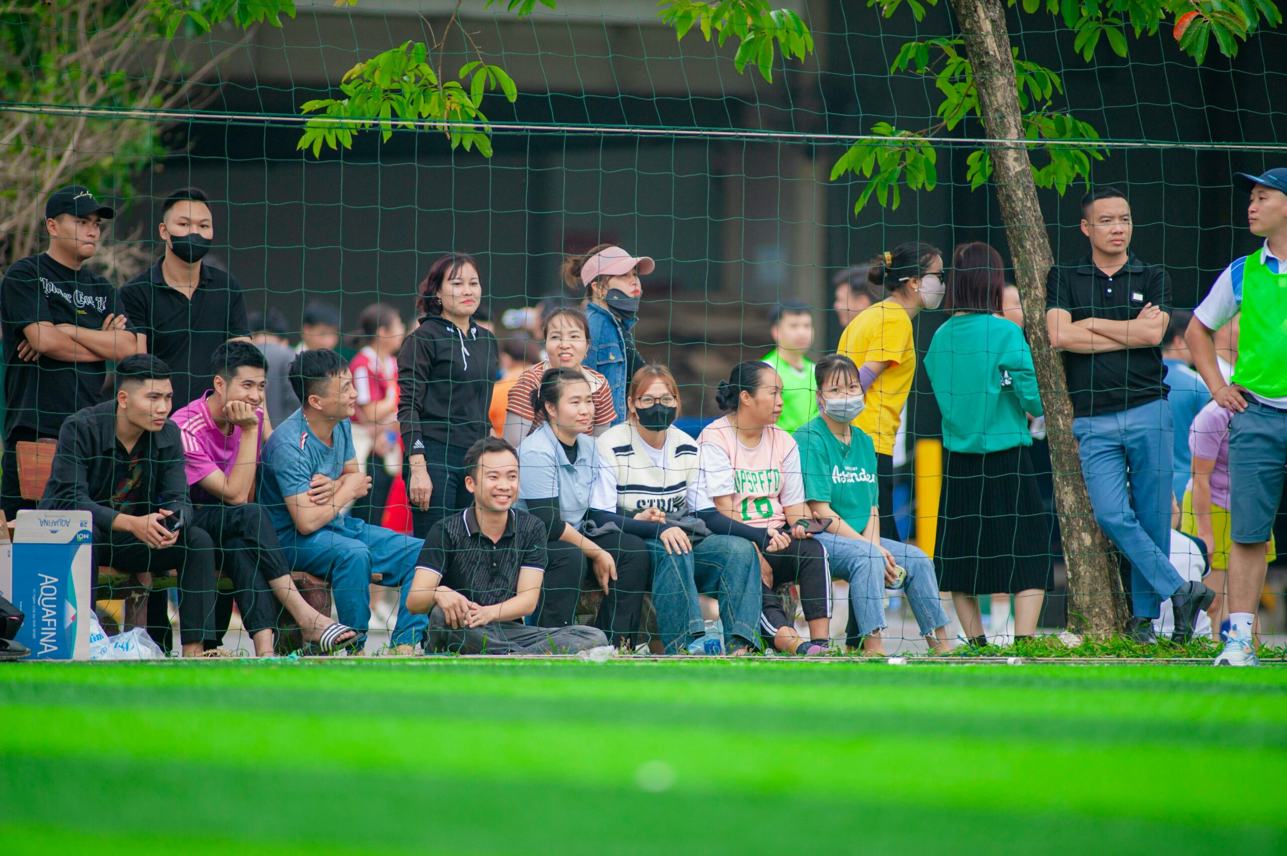 Eine Gruppe von Zuschauern versammelte sich im Freien, um ein Fußballspiel in Hanoi, Vietnam anzuschauen.